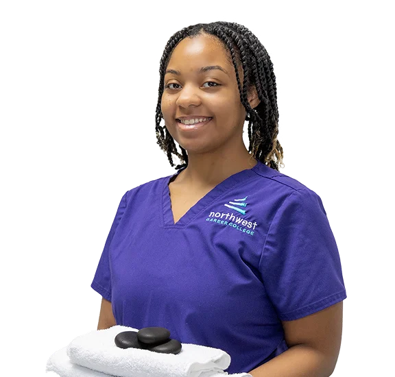 Massage Therapy School student in Las Vegas at Northwest Career College holding towels and hot stones