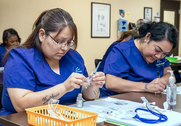Medical Assistant class in Las Vegas with students practicing syringe preparation at Northwest Career College