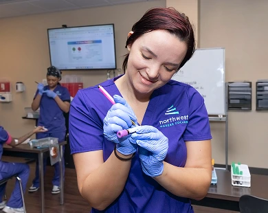 Phlebotomy school student in Las Vegas at Northwest Career College practicing blood sample handling in class